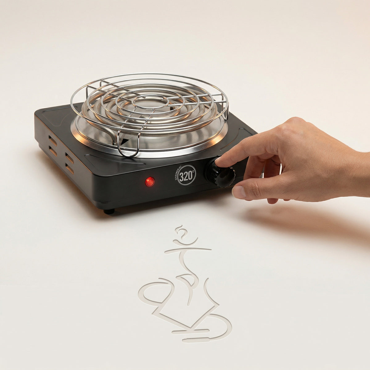 A hand resting on the 320 electric charcoal burner control knob in a warm white studio, showing the real-world size of the 1000W burner, brushed stainless coil and chrome safety grid available at The Premium Way., image 5 of 12