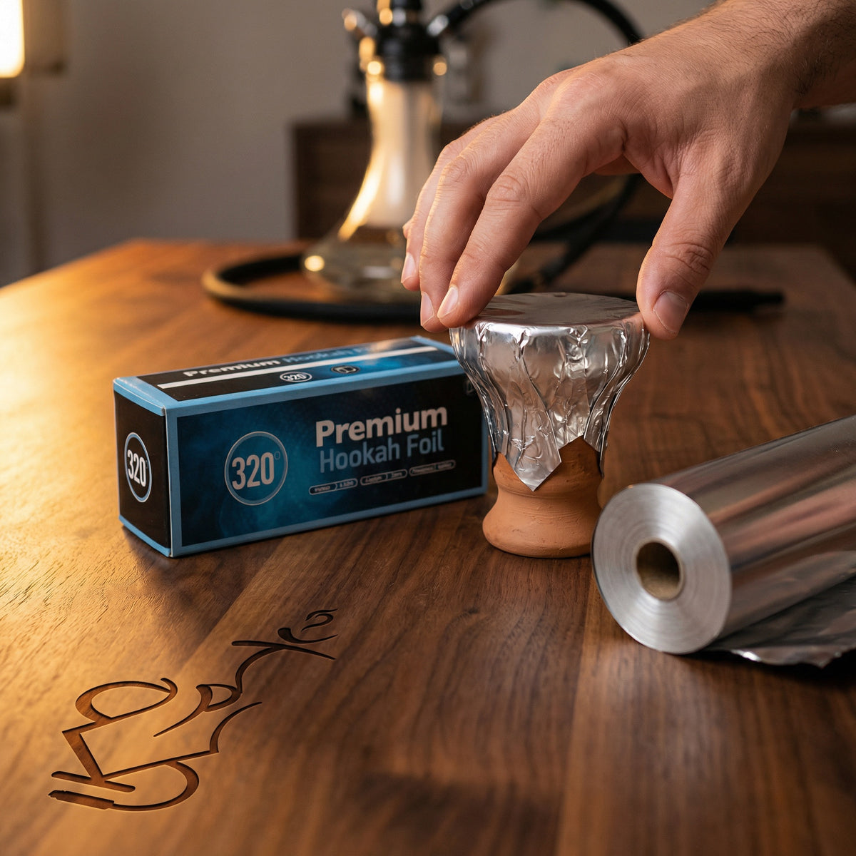 320° Shisha Foil dispenser box and roll in a real hookah session, with foil being smoothed across a packed clay bowl to show the heavy 40-micron aluminium in use., image 9 of 13