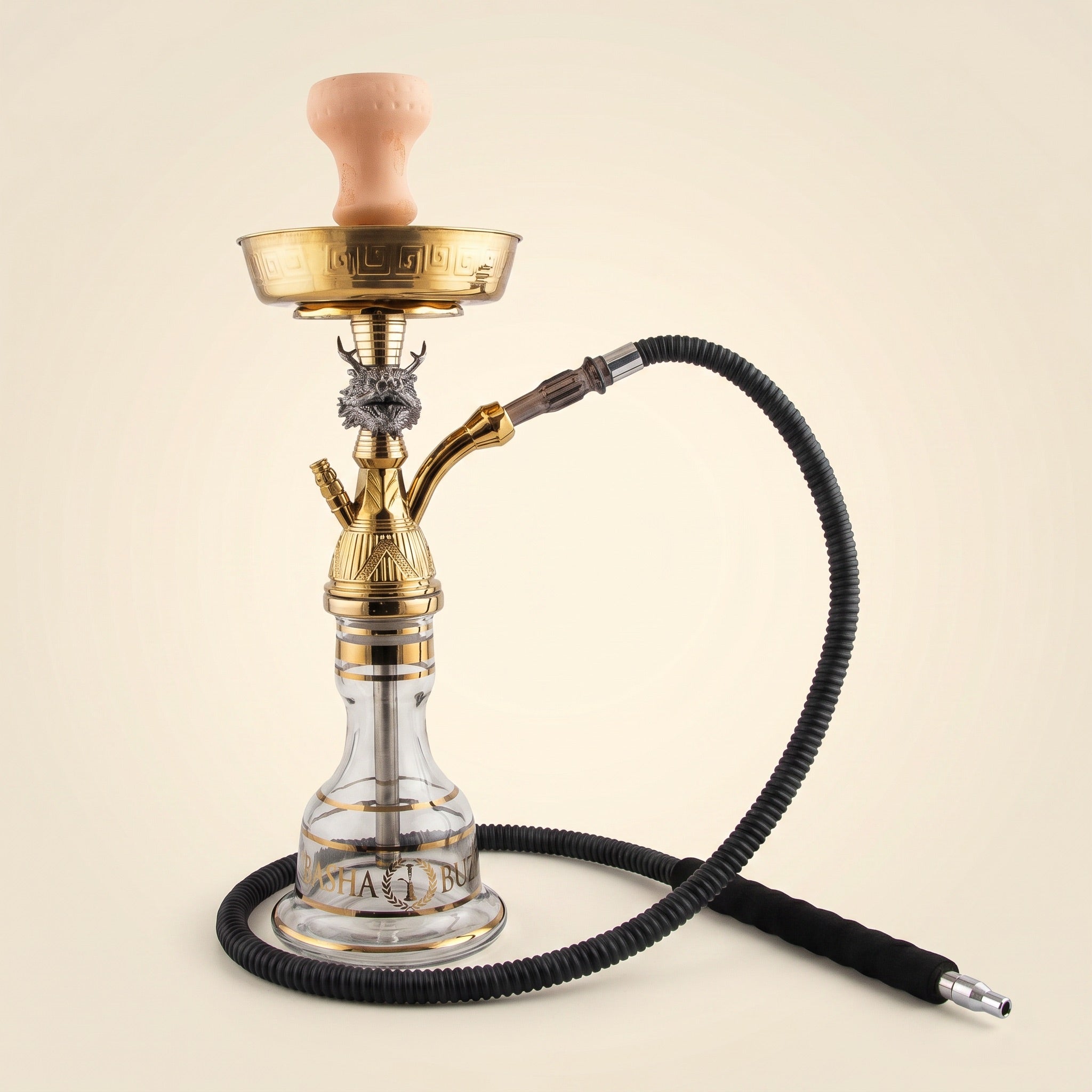 Basha Buzz Draco hookah pipe with silver dragon head figurine and gold stem on warm cream studio backdrop