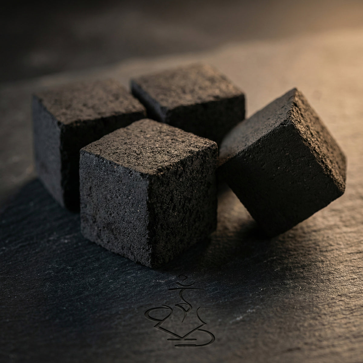 Close-up macro of Cerberus Coco 26mm coconut shisha charcoal cubes on dark slate showing the dense compressed coconut shell surface texture and precise geometry., image 8 of 11