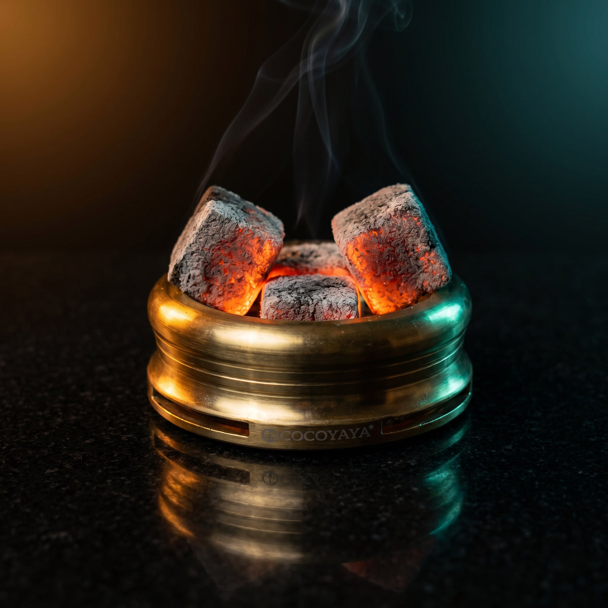 Cocoyaya Pro 5 HMD with lit coconut coals, brushed gold body on polished black stone, premium lounge atmosphere, image 2 of 5