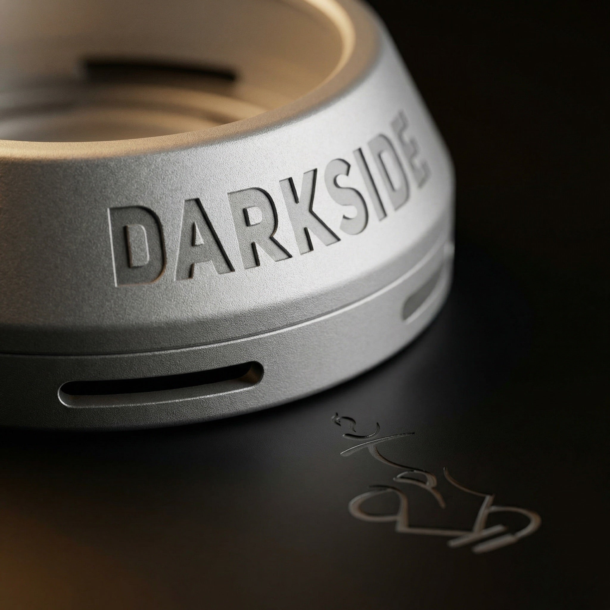 Extreme macro of the Darkside D-Heater's anodised aluminium surface, highlighting the blasted satin texture, vent slot geometry, and debossed wordmark detail.