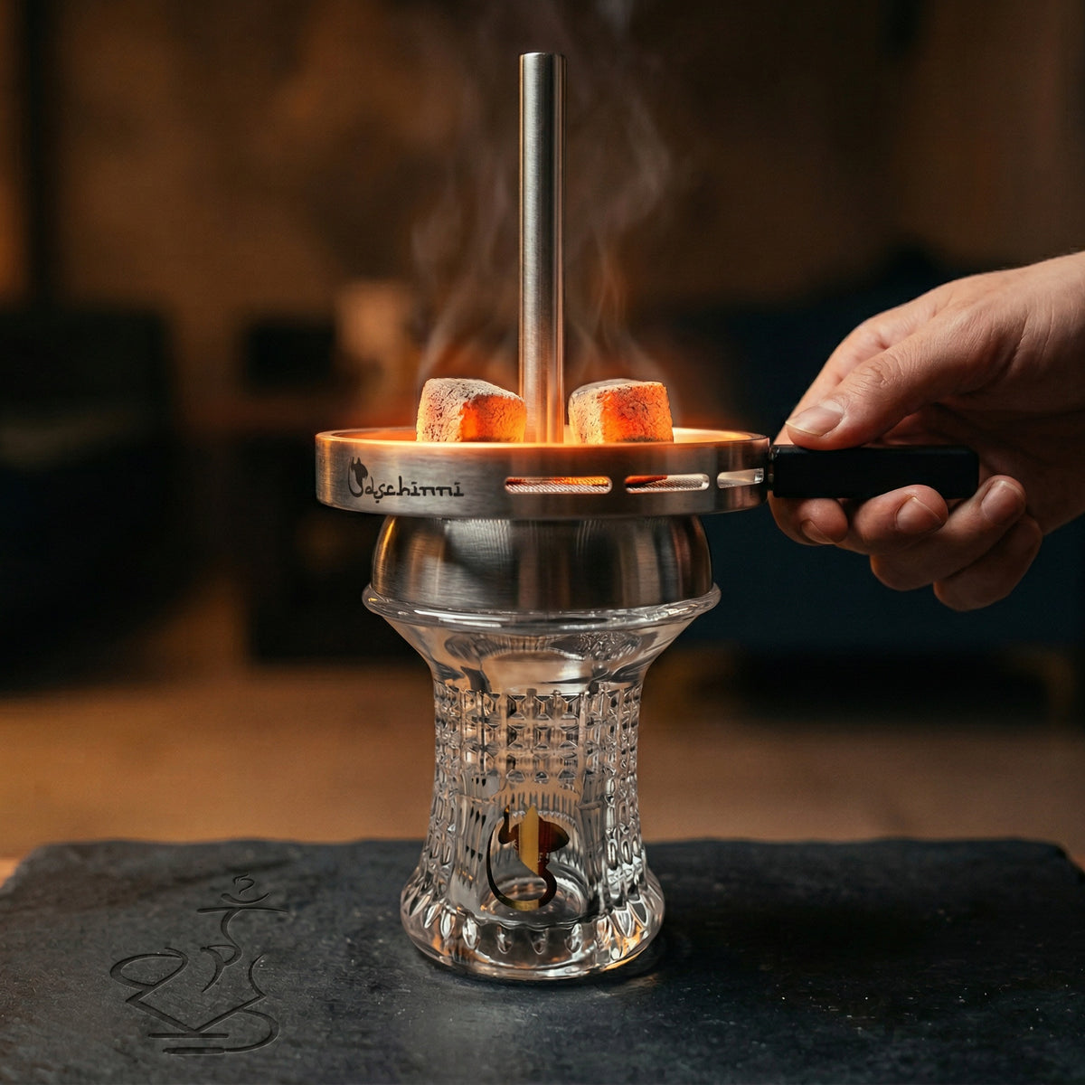 Dschinni Nero Glass Head Bundle assembled in a hookah session with glowing coals inside the Vulcan Air 2.0 chimney, hand adjusting the handle, warm lounge atmosphere., image 2 of 9