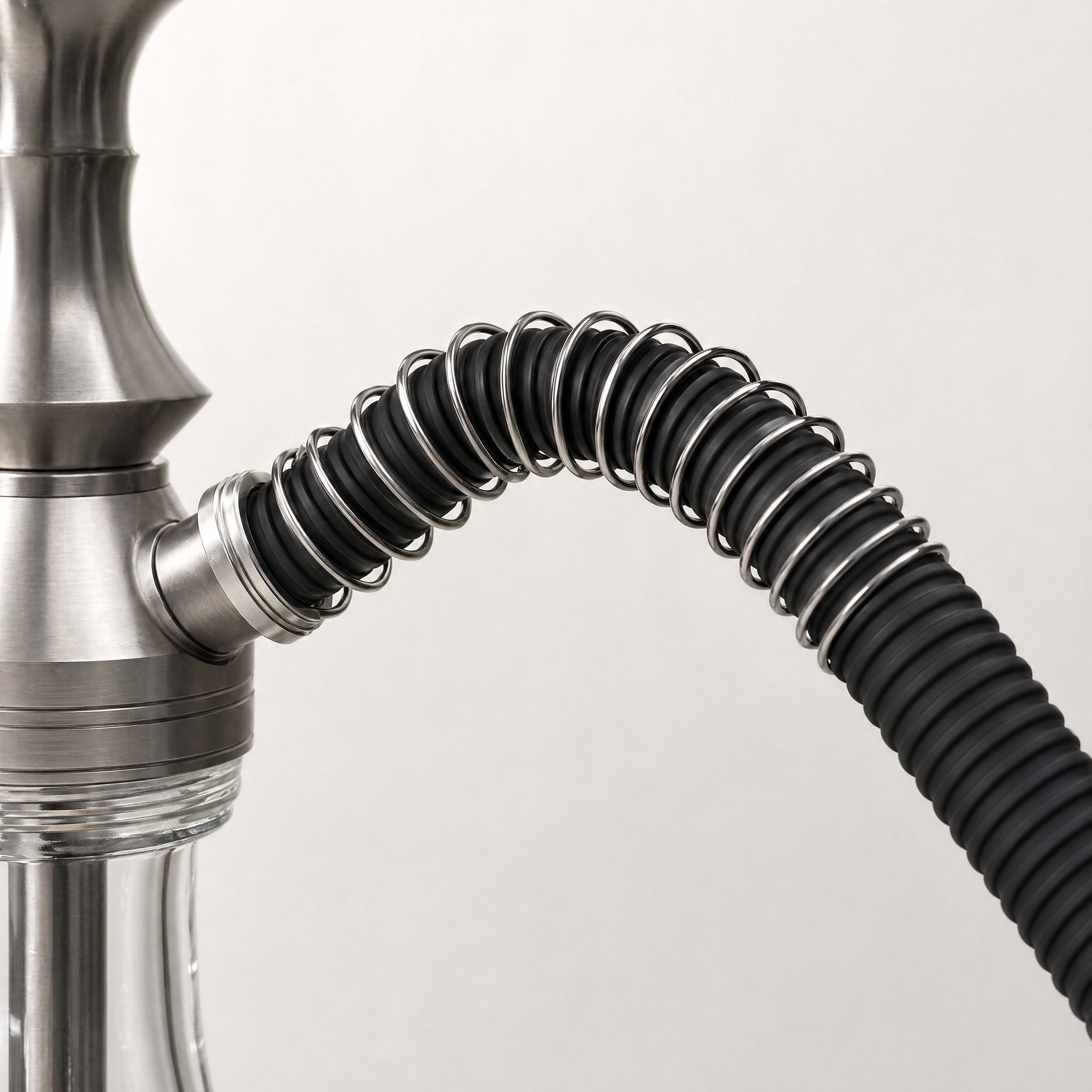 Essentials anti-kink spring installed on a black silicone hookah hose at the connection point preventing kinking