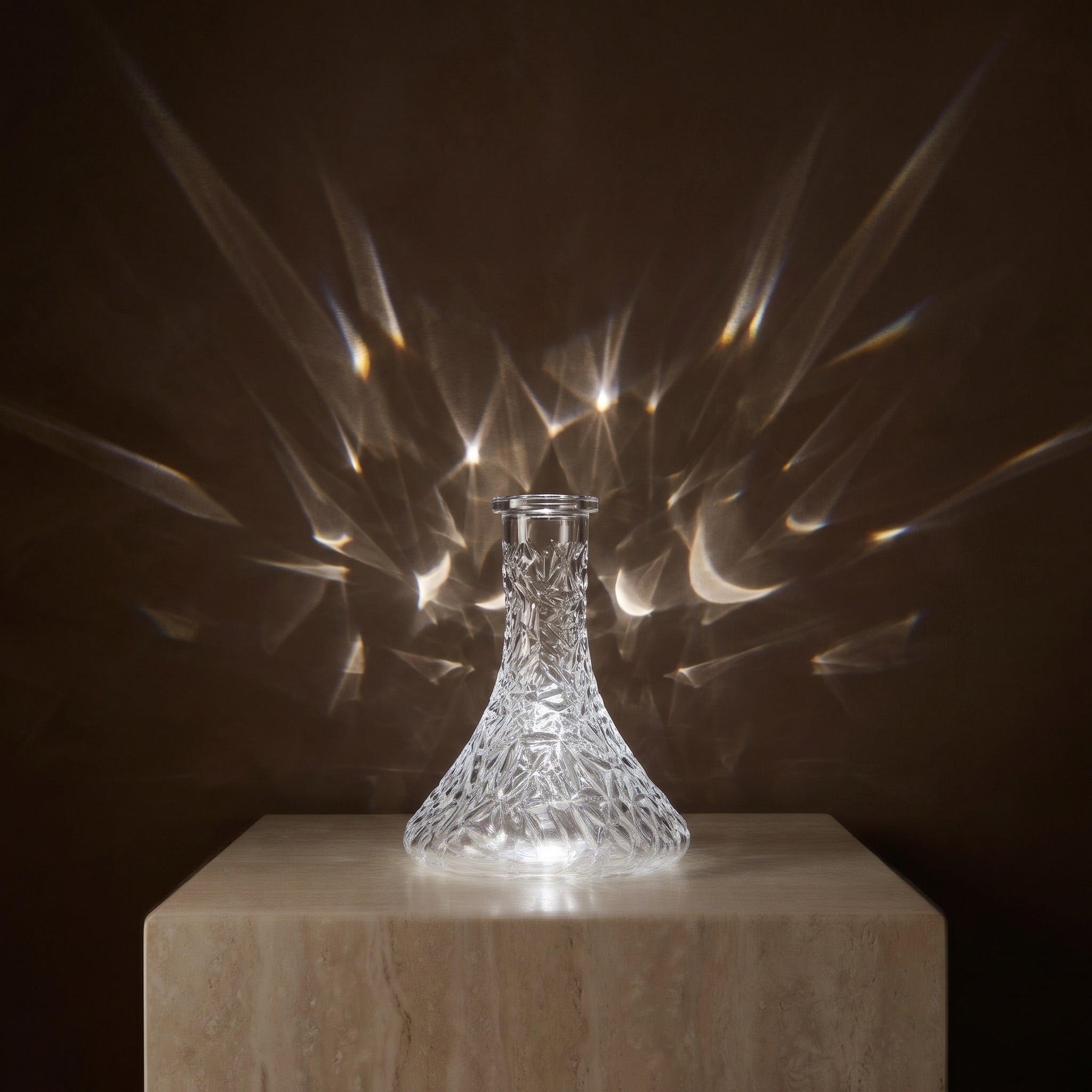 Essentials Crystal-Cut Clear Russian shisha vase on travertine plinth, refracted light fanning across the wall behind