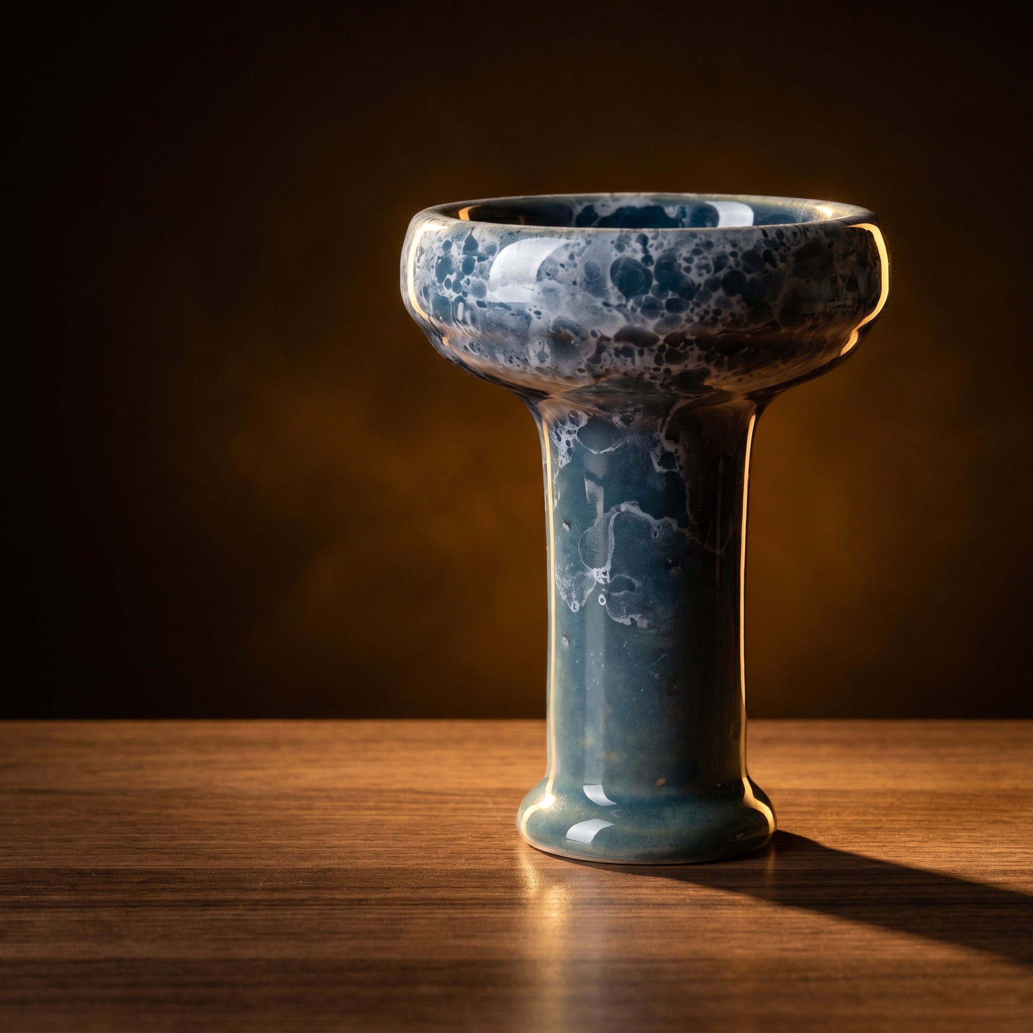 Essentials Joker Phunnel in Tsunami glaze on wet-look dark slate with warm amber rim light and faint atmospheric haze.