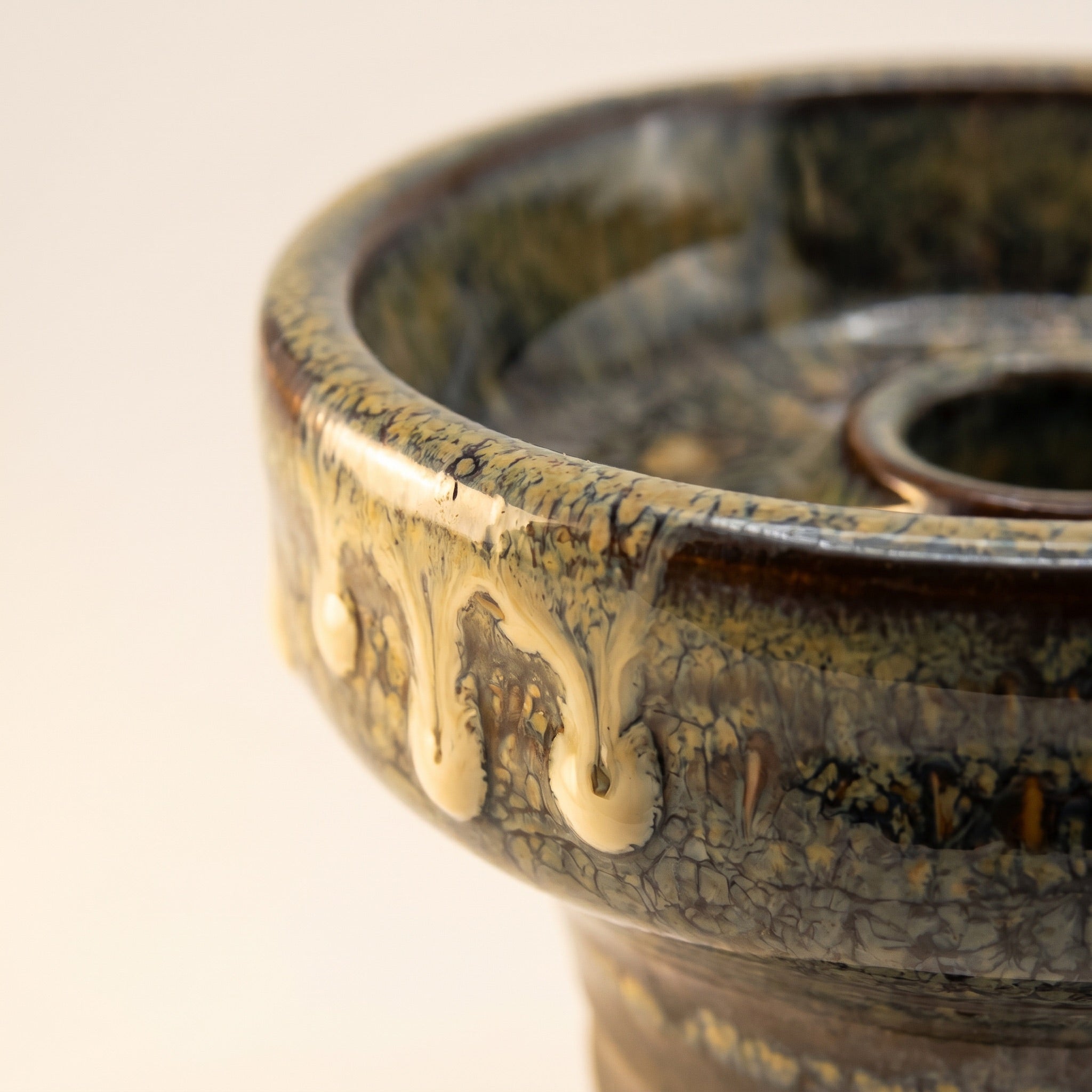 Close-up macro of Sentinel glaze on Knight Phunnel Bowl showing cream drip tongues over olive crystalline