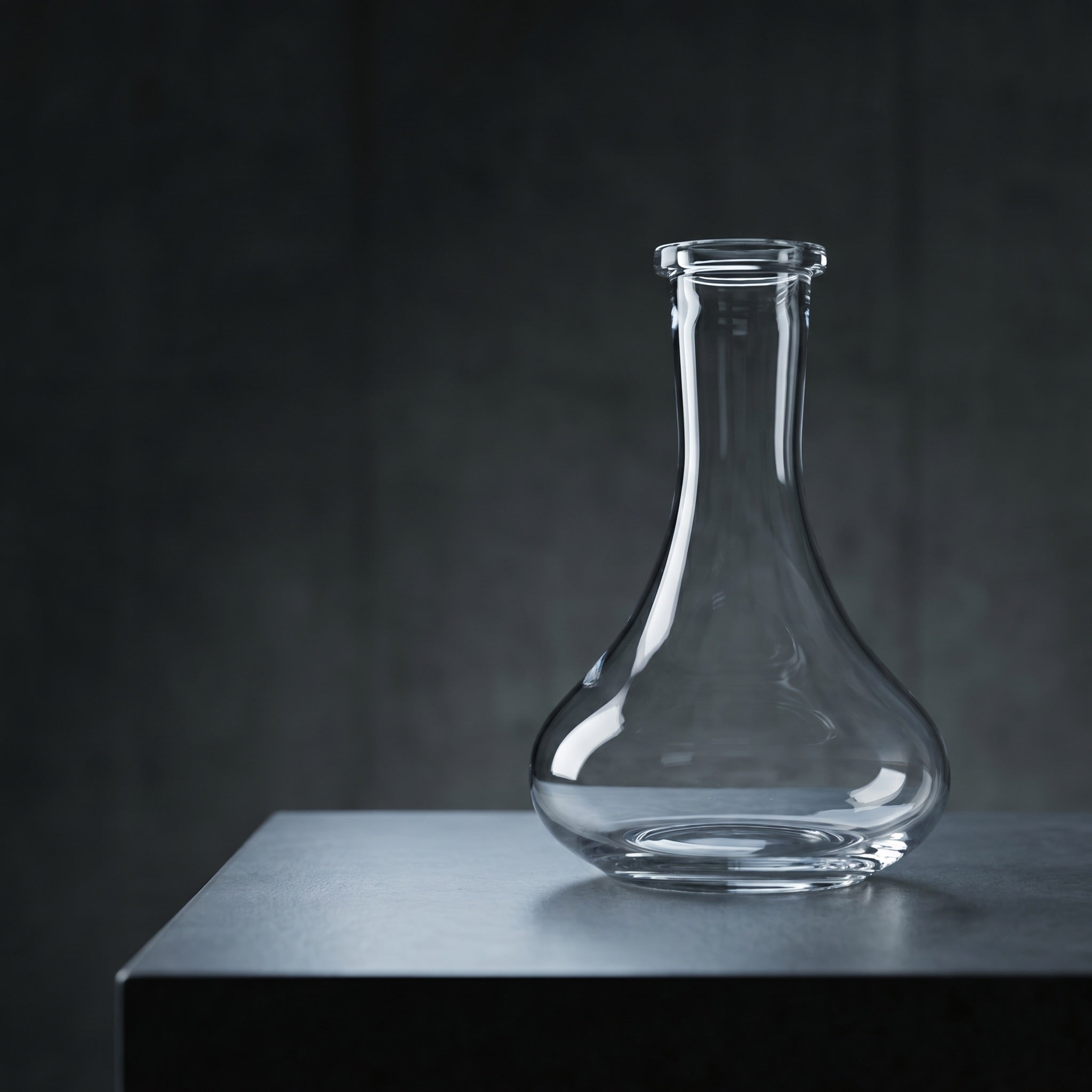Essentials Tear Drop clear glass shisha vase on dark concrete plinth, modern architectural lighting, Russian-fit replacement base