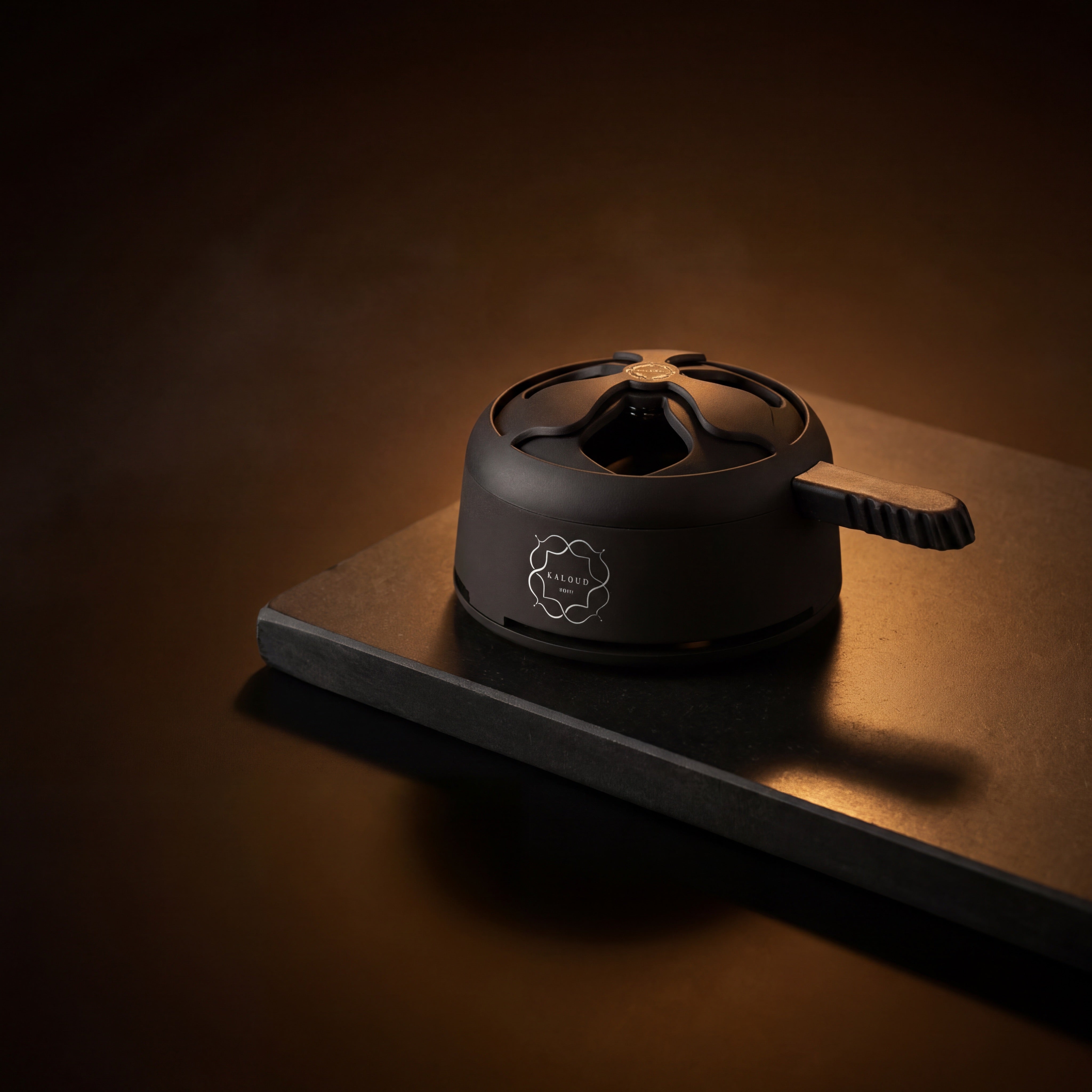 Matte black Kaloud Lotus I+ Niris HMD on a dark stone slab under warm amber lighting at The Premium Way.
