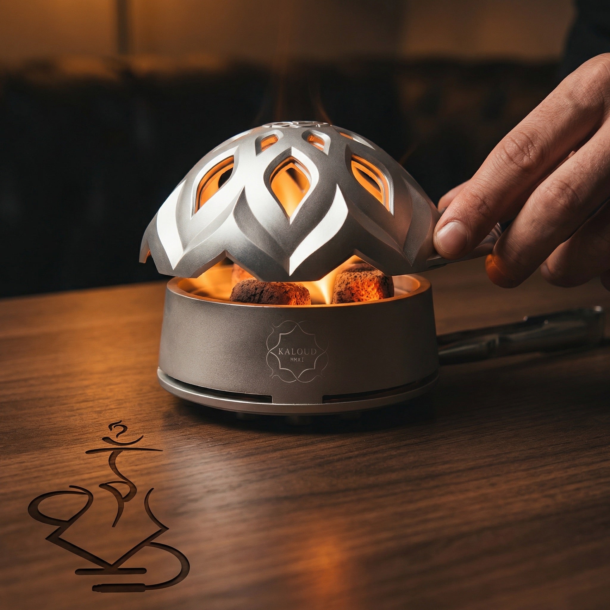 Kaloud Lotus I+3 Argis Silver HMD with glowing coconut coals visible through the lotus lid cutouts, hand lifting the lid during a hookah session on a walnut bar top.