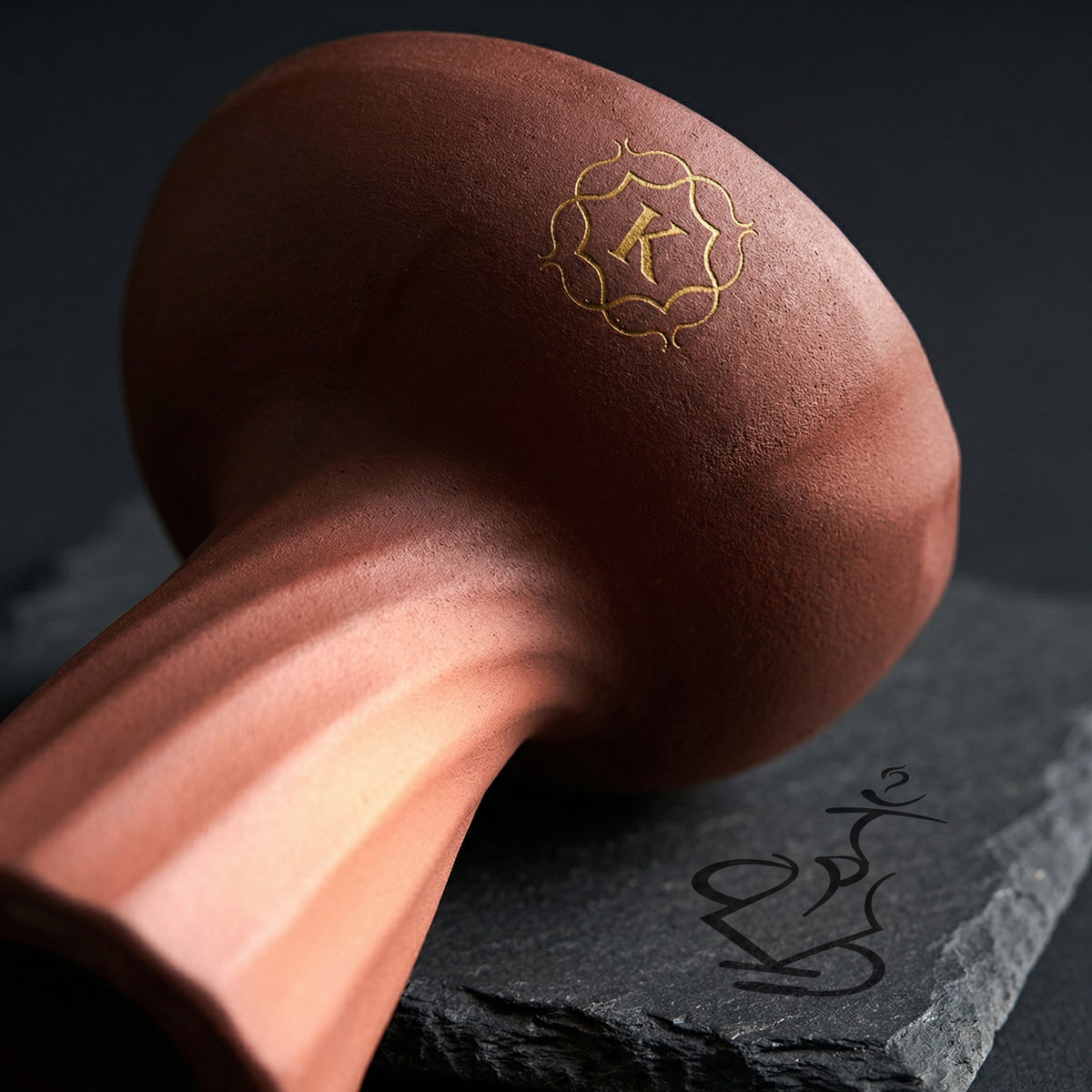 Close-up macro detail of Kaloud Samsaris Kore Qì porous red clay surface showing spiral twist ribbing grain texture and gold K crest, image 6 of 18