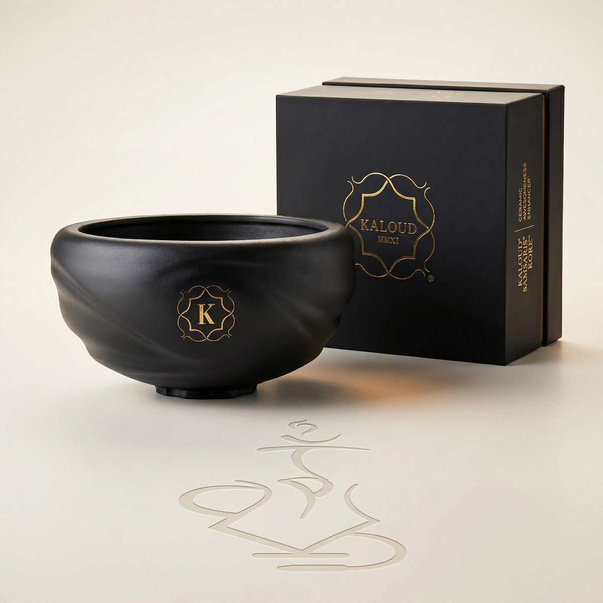 Kaloud Samsaris Kore Qì Short black clay shisha bowl with premium black-and-gold Kaloud presentation box on a warm white studio background, image 3 of 11