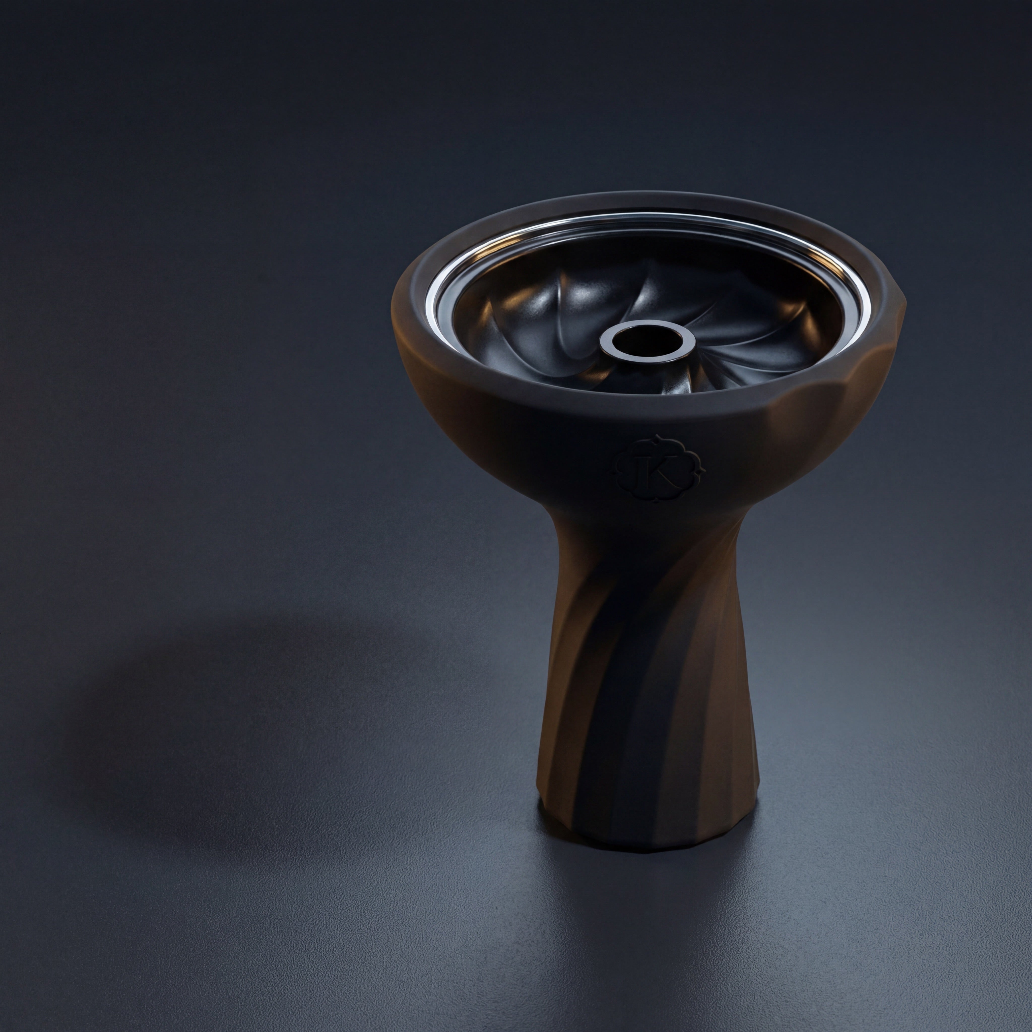 Kaloud Samsaris Lapis II ceramic shisha bowl on polished slate in dim modern interior with warm directional light catching the chrome ring