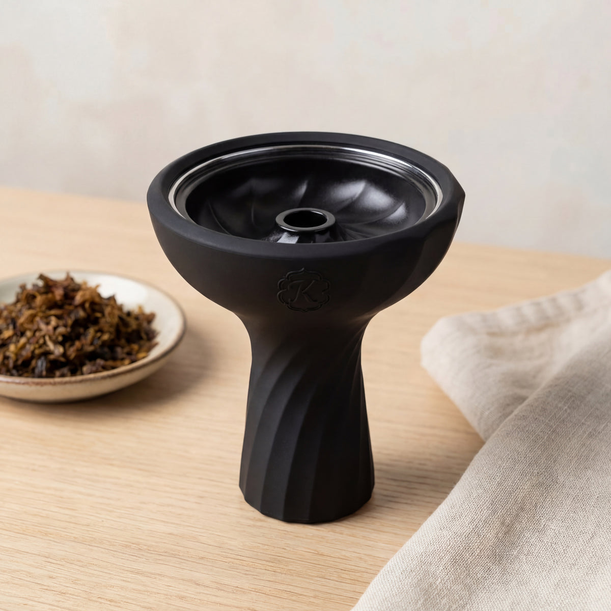 Kaloud Samsaris Lapis II ceramic shisha bowl on pale oak surface with shisha leaf in ceramic dish and linen cloth, image 3 of 13