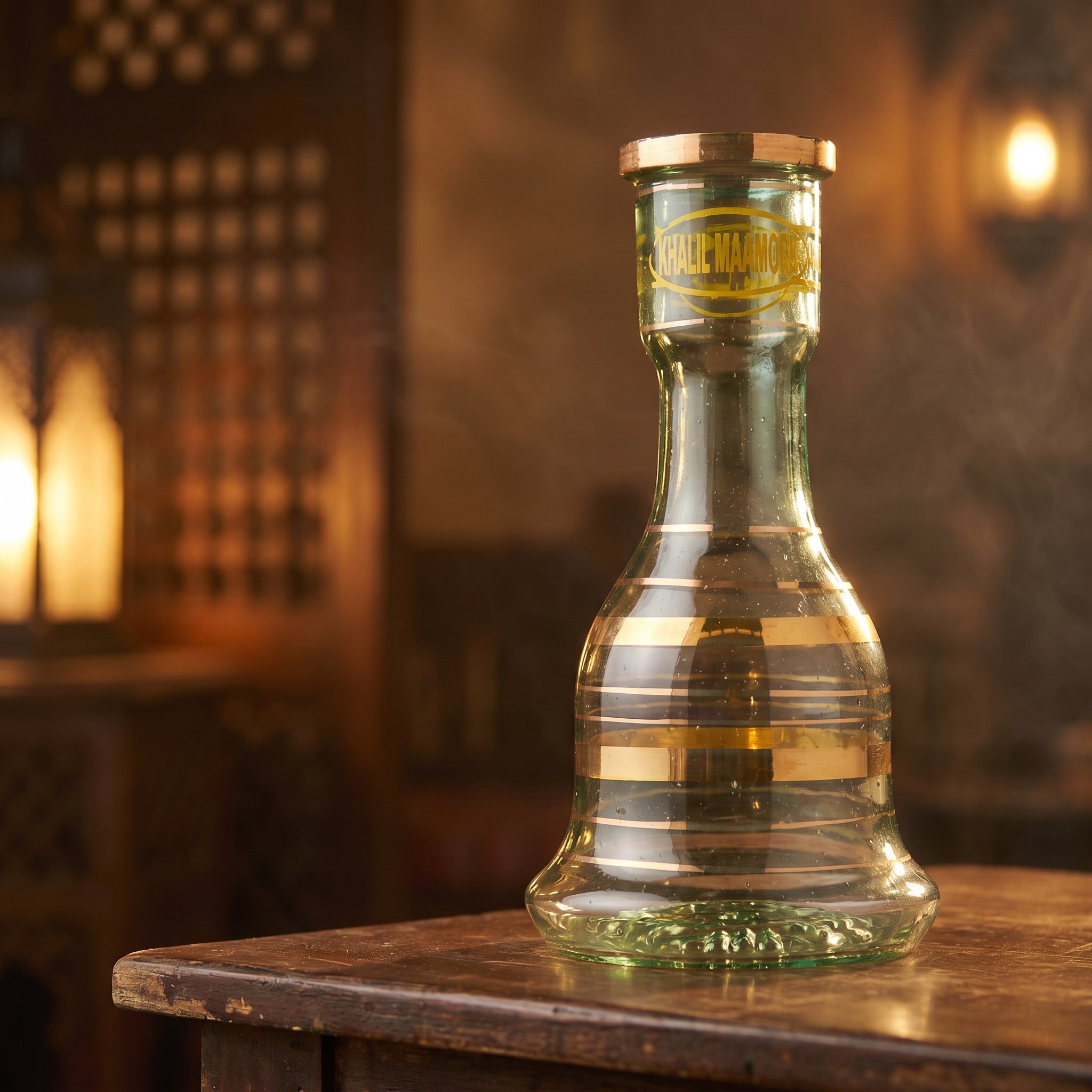 Khalil Mamoon 30 cm gold-banded glass base backlit on a dark-wood Cairo-style café table at dusk