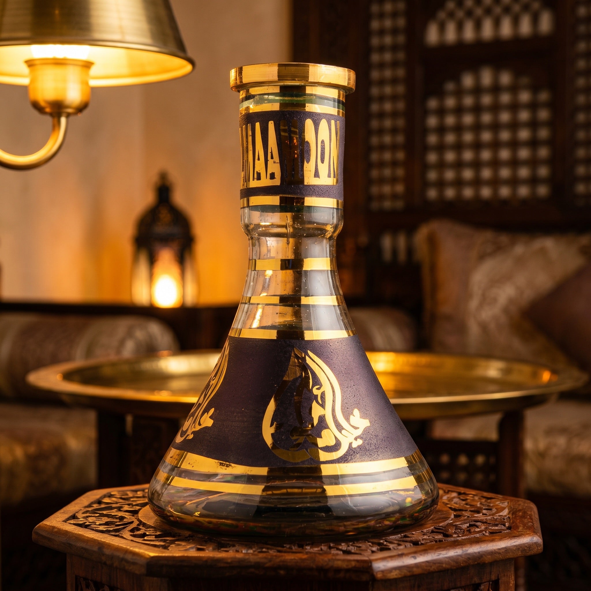 Khalil Mamoon 30cm black and gold shisha base on carved wood table in warm-lit majlis lounge