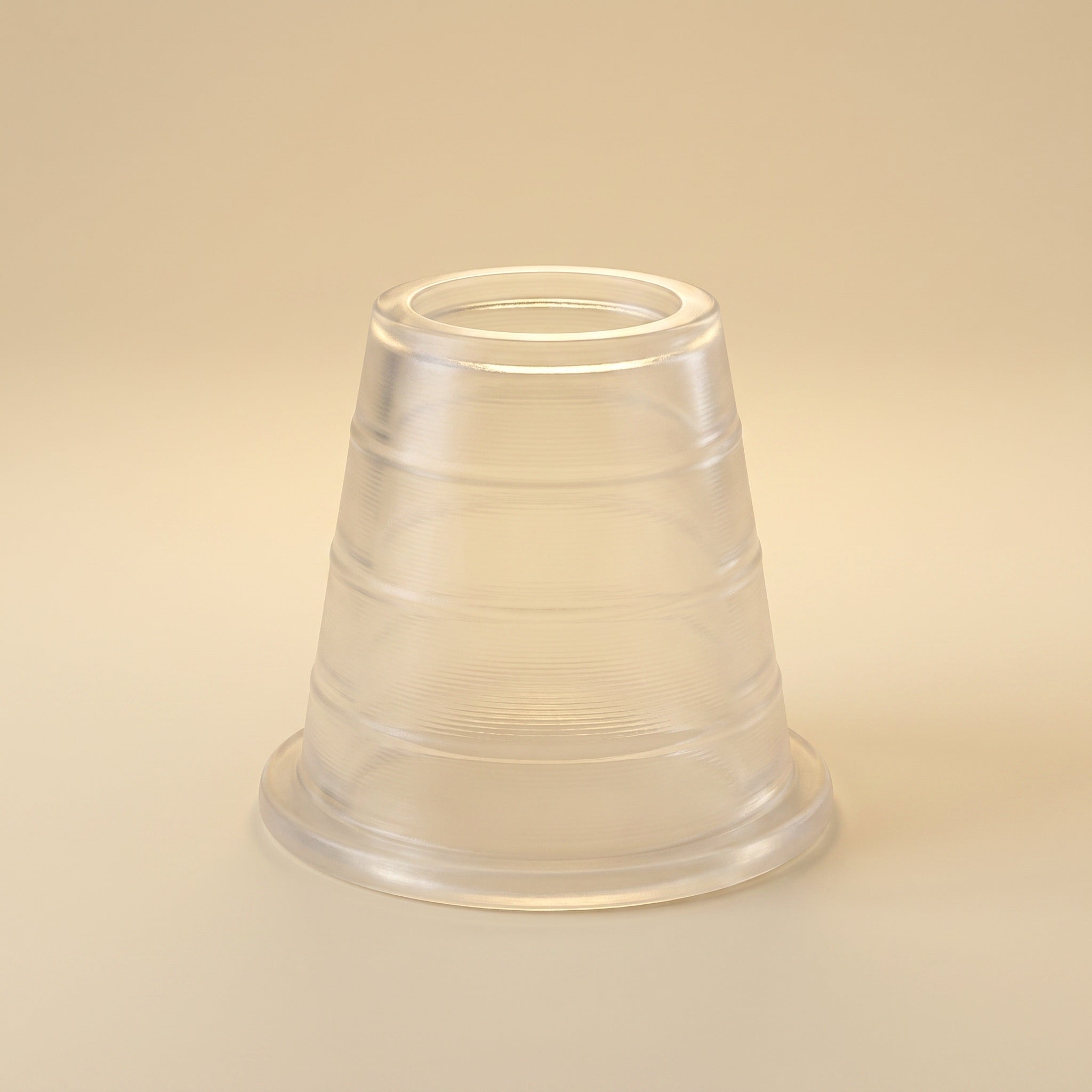 Khalil Mamoon hose grommet, translucent rubber with ridged body and flanged base, on warm cream studio background