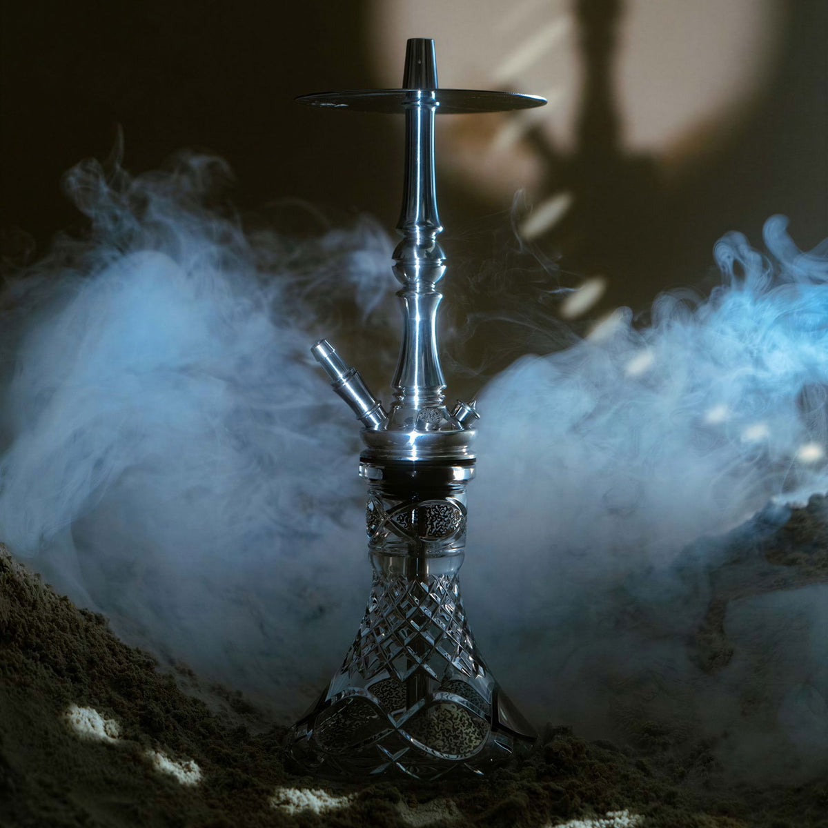 Moze Tradi M Silver traditional shisha in a cool smoky setting with blue haze, polished chrome stem on a cut-glass base, image 7 of 7