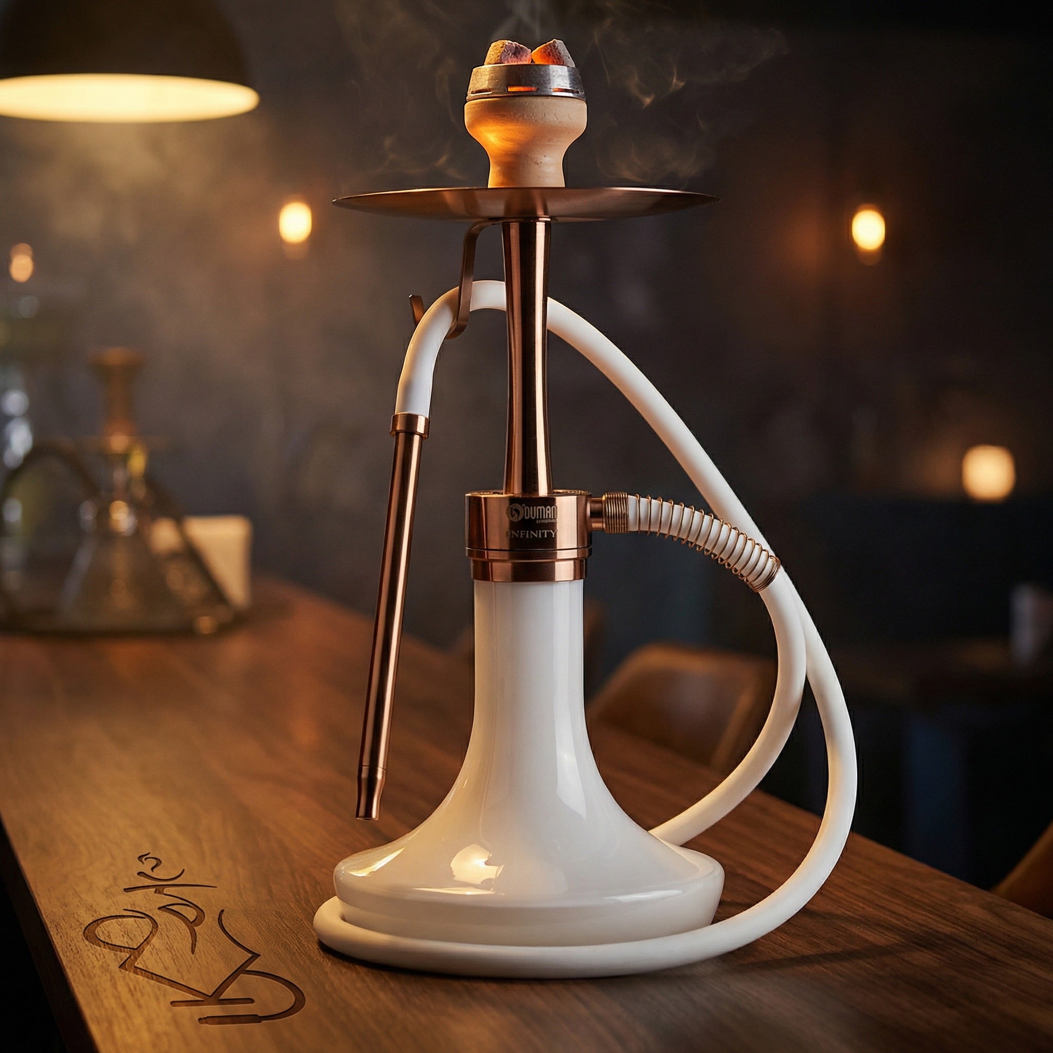 Oduman Infinity bronze and white glass shisha pipe set up for a lounge session with a loaded bowl and glowing coals on a dark walnut bar top.