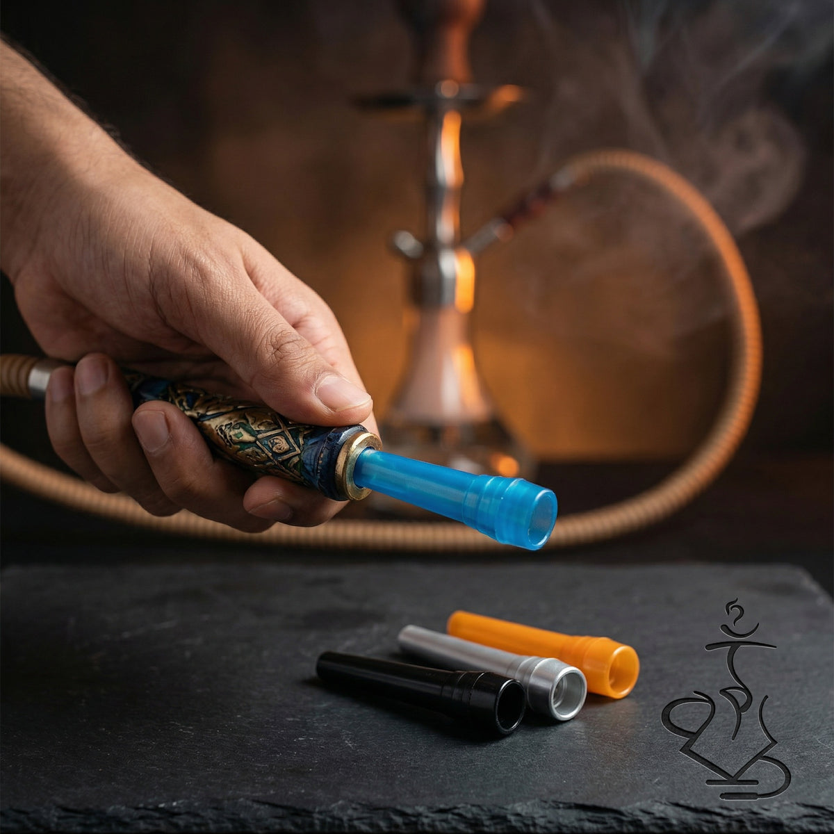 ShishaDoc disposable mouth tip in blue inserted into a hookah mouthpiece during a session with additional colour options on the table, image 3 of 18