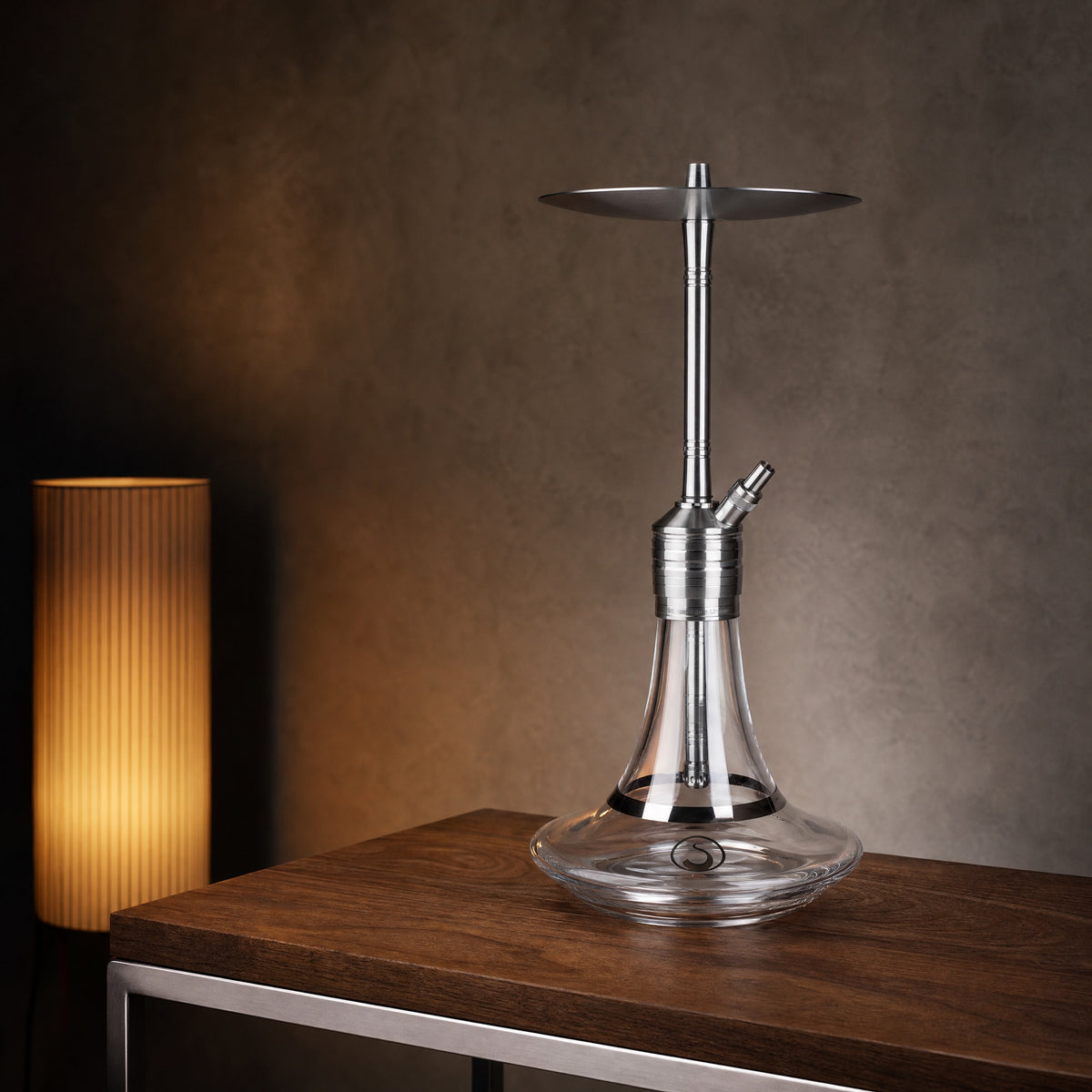 Steamulation Ultimate One Gen II clear shisha pipe on walnut side table in modernist interior at dusk, image 3 of 5
